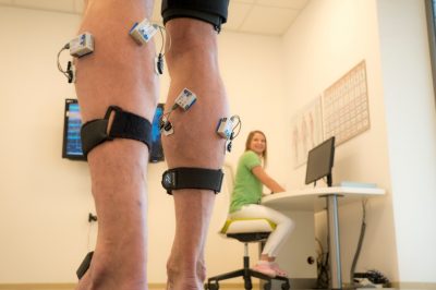 Patient mit EMG- und Inertialsensoren an den Beinen
